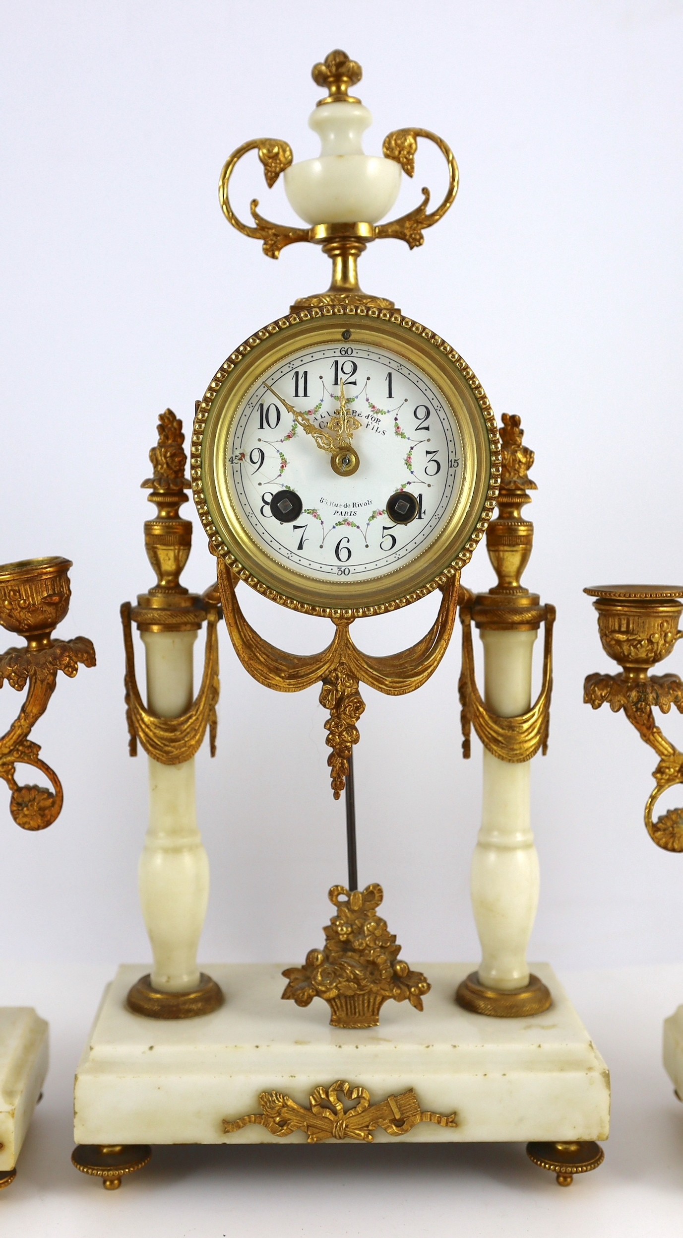 A Louis XVI style ormolu mounted white marble eight day mantel clock and a matching pair of twin branch candelabra. 38.5cm tall